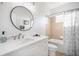 Bright bathroom featuring a modern vanity, round mirror, and a bathtub with neutral tile at 11310 Grand Winthrop Ave, Riverview, FL 33578