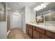 This bathroom is equipped with double sinks, a large mirror, and decorative vanity lighting at 11415 Green Harvest Dr, Riverview, FL 33578