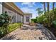 Paver brick pathway winds through lush landscaping with palm trees in this serene backyard setting at 14605 Chatsworth Manor Cir, Tampa, FL 33626