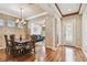 Elegant dining area with hardwood floors, a decorative chandelier, and an open view to the living room at 14605 Chatsworth Manor Cir, Tampa, FL 33626