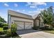 Charming home with stone accents, a well-manicured lawn, and a two-car garage in a suburban setting at 14605 Chatsworth Manor Cir, Tampa, FL 33626