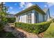 Well-maintained home exterior featuring manicured hedges and a brick pathway, all under a bright sky at 14605 Chatsworth Manor Cir, Tampa, FL 33626