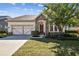 Beautiful single-story home with stone accents, a well-manicured lawn, and an inviting front entrance at 14605 Chatsworth Manor Cir, Tampa, FL 33626