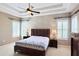 Cozy bedroom with decorative ceiling, shutters, and a large bed at 14605 Chatsworth Manor Cir, Tampa, FL 33626