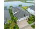 Aerial view of home showcasing a three car garage, paver driveway, landscaping and lake view at 14610 Red Castle Ave, Lithia, FL 33547