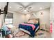 Bright bedroom featuring a ceiling fan, a patterned rug, a canopy bed, and a desk at 14610 Red Castle Ave, Lithia, FL 33547