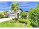 Stunning home featuring tropical landscaping and a three-car garage with an arched entryway at 14610 Red Castle Ave, Lithia, FL 33547