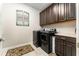 Convenient laundry room featuring a washer, dryer, and ample dark wood cabinet space for storage at 14610 Red Castle Ave, Lithia, FL 33547