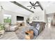 Spacious living room with a ceiling fan, wood beams, stylish furniture, and plenty of natural light at 14610 Red Castle Ave, Lithia, FL 33547