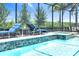 Outdoor luxury featuring a tiled spa spilling into a shimmering pool, surrounded by lush landscaping at 14610 Red Castle Ave, Lithia, FL 33547
