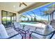 Screened-in patio with a pool and hot tub, accompanied by comfortable seating and lush landscaping at 14610 Red Castle Ave, Lithia, FL 33547
