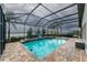 Screened-in pool and patio area offering a spa, lounge chairs, and serene views of the lake at 14610 Red Castle Ave, Lithia, FL 33547