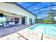 Inviting pool area with covered patio, outdoor seating, and views into the home through sliding glass doors at 14610 Red Castle Ave, Lithia, FL 33547