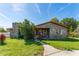 Quaint home featuring wood siding, a stone chimney, and a spacious front yard on a sunny day at 1501 W Trapnell Rd, Plant City, FL 33566