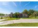 Quaint home featuring wood siding, a stone chimney, and a spacious front yard on a sunny day at 1501 W Trapnell Rd, Plant City, FL 33566