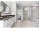 Neutral bathroom featuring a glass-enclosed shower, granite counters, and tile flooring at 1550 Marinella Dr, Palm Harbor, FL 34683