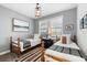 Charming bedroom with two twin beds, soft gray walls, and natural light streaming in from the windows at 1550 Marinella Dr, Palm Harbor, FL 34683