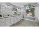 Bright bathroom with large vanity, granite countertops, arched window, and tile floors at 15618 Shoal Creek Pl, Odessa, FL 33556
