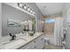 Bathroom with granite countertops, dual sinks, and a combination shower and tub at 15618 Shoal Creek Pl, Odessa, FL 33556