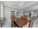 Formal dining room with wood table, modern chandelier, and views into the living room and kitchen at 15618 Shoal Creek Pl, Odessa, FL 33556