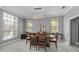Dining area with light-colored walls, wood table set and large windows with views to the outside at 15618 Shoal Creek Pl, Odessa, FL 33556
