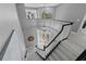 Grand foyer with white staircase and black railings, leading to a light-filled entryway with decorative glass doors at 15618 Shoal Creek Pl, Odessa, FL 33556