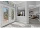 Bright foyer featuring a decorative glass door, gray flooring, and a view into the dining and living areas at 15618 Shoal Creek Pl, Odessa, FL 33556