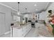 Open kitchen with stainless steel appliances, large island, white cabinets, and modern pendant lighting at 15618 Shoal Creek Pl, Odessa, FL 33556