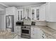 Close up of kitchen with stainless appliances, white cabinetry, and decorative backsplash at 15618 Shoal Creek Pl, Odessa, FL 33556