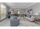 Bright living room featuring neutral furniture, gray walls, large window, and open access to the dining area at 15618 Shoal Creek Pl, Odessa, FL 33556