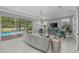 Comfortable living area with pool view, stylish furnishings and ample natural light, creating an inviting and relaxing space at 15618 Shoal Creek Pl, Odessa, FL 33556
