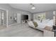 Large main bedroom featuring light wood floors, a TV on a dresser, and access to a private patio at 15618 Shoal Creek Pl, Odessa, FL 33556