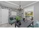 Home office with stylish wallpaper, ample desk space, and a view of the living area and pool at 15618 Shoal Creek Pl, Odessa, FL 33556
