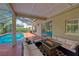 Relaxing screened-in patio features comfortable seating, a modern fire pit, and views of the sparkling pool at 15618 Shoal Creek Pl, Odessa, FL 33556