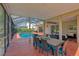 Inviting screened-in patio area featuring a dining table, pool, and comfortable seating area for outdoor enjoyment at 15618 Shoal Creek Pl, Odessa, FL 33556