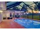Beautiful screened-in pool area with patio lighting, a seating area, and a dining space for entertaining at 15618 Shoal Creek Pl, Odessa, FL 33556
