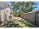 View of the fenced backyard showing plenty of space with grass and tree coverage at 18406 Sterling Silver Cir, Lutz, FL 33549