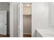 Bright bathroom with white vanity, open closet and wood-look floors creates a fresh, modern space at 18406 Sterling Silver Cir, Lutz, FL 33549