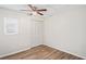 Bedroom with light walls, a ceiling fan and wood-look floors, plus closet and window at 18406 Sterling Silver Cir, Lutz, FL 33549