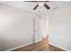 Bright bedroom with wood-look floors, ceiling fan, and an open doorway at 18406 Sterling Silver Cir, Lutz, FL 33549
