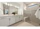 Bathroom featuring a glass shower, double sinks, and modern lighting fixtures at 1982 Pepper Grass Dr, North Port, FL 34289