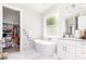 Bright bathroom features a freestanding tub, marble surround, walk-in closet, and vanity at 2202 Yalta Ter, North Port, FL 34286