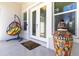 Inviting front porch with a hanging chair, decorative jar, and double-door entry at 2202 Yalta Ter, North Port, FL 34286