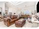 Open-concept living room with leather sofa, light wood floors, and a view of the kitchen and dining area at 2202 Yalta Ter, North Port, FL 34286