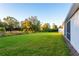 Expansive backyard with lush green grass and a view of the tree line at 24276 Peppercorn Rd, Punta Gorda, FL 33955