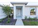 Inviting home entrance featuring a white front door, modern concrete pathway, and lush landscaping at 24276 Peppercorn Rd, Punta Gorda, FL 33955