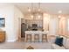 Open-concept kitchen with gray cabinets, a kitchen island with seating, and stainless steel appliances at 24276 Peppercorn Rd, Punta Gorda, FL 33955