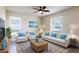 Bright living room featuring neutral furniture, stylish rug, and a ceiling fan for comfort at 24276 Peppercorn Rd, Punta Gorda, FL 33955