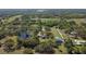 Aerial view showing the vast countryside with lush trees and a serene pond at 27547 Miller Rd, Dade City, FL 33525