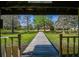 Stunning view of a long wooden pier stretching towards a gazebo, nestled on a serene, tree-lined lake at 27547 Miller Rd, Dade City, FL 33525